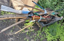 A WHEELBARROW WITH GARDENING TOOLS including spades, forks, clippers, drain rods etc