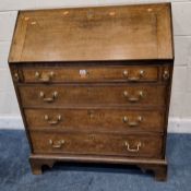 A GEORGIAN OAK BUREAU, the fall front door enclosing a fitted interior, over four graduated drawers,