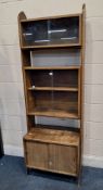 A MID-CENTURY TEAK MODULAR BOOKCASE, with two pairs of glass sliding doors, over double sliding