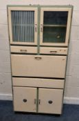 A 20TH CENTURY GREEN AND CREAM PAINTED KITCHEN LARDER, fitted with two glass doors, two drawers, a