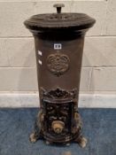 A GODIN CAST IRON STOVE, with a hinged lid, a tube to the rear, the front with a single door, raised