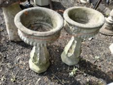 A PAIR OF MODERN CONCRETE URNS ON STAND, with fluted bowls, floral motifs and balustered bases, 73cm