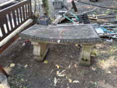 A CURVED CONCRETE GARDEN BENCH with two scrolled supports, 115cm long Condition Report:weathered