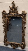A REPRODUCTION GILT RESIN WALL MIRROR, with scrolled, foliate and floral details Dimensions:width