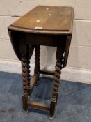 AN EARLY 20TH CENTURY OAK GATE LEG TABLE, raised on barley twist supports, united by stretchers