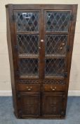 A 20TH CENTURY OAK CORNER CUPBOARD, the top double doors with six lead glazed panes, above two