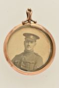 A YELLOW METAL DOUBLE PHOTOGRAPH PENDANT, of a circular form, holding two black and white photos