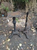 TWO CAST IRON TABLE BASES, one with four feet, foliate detail to stem, and a plate to top, along