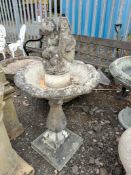 A CONCRETE GARDEN WATER FEATURE with a balustered base, acanthus leaf detail to the bowl, and a