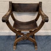 A 20TH CENTURY OAK FRAMED FOLDING SAVONAROLA CHAIR, with leather backrest and seat, open armrests,