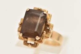 A YELLOW METAL SMOKY QUARTZ DRESS RING, four claw set with a rectangular cut smoky quartz, measuring