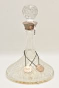 A GLASS DECANTER WITH SILVER COLLAR AND TWO SILVER DECANTER LABELS, the collar of the decanter