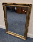 A GILT WOOD RECTANGULAR BEVELLED EDGE WALL MIRROR, with scrolled and foliate details Dimensions: