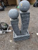 A MODERN GREY PLASTIC WATER FEATURE with brickwork effect base/ reservoir, stacked slate effect