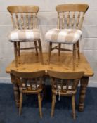 A MODERN PINE RECTANGULAR KITCHEN TABLE, raised on block and turned legs, along with a set of four