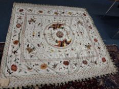 A SILK THROW, hand embroidered with Chinese motifs including dragons, exotic birds and flowers, in