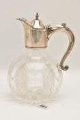 A SILVER MOUNTED CUT GLASS DECANTER, fitted with a silver hinged cover, scrolling rim and scroll