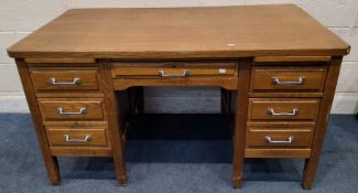 AN EARLY 20TH CENTURY OAK KNEE HOLE DESK, fitted with two slides and six assorted drawers
