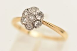 AN 18CT GOLD DIAMOND CLUSTER RING, designed as a small flower set with seven small old cut diamonds,