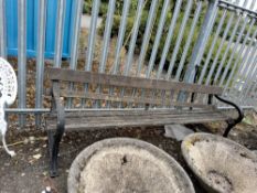 A GARDEN BENCH WITH VICTORIAN CAST IRON ENDS and distressed wooden slatted seat and back, 230 cm