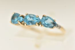 A 9CT GOLD GEM SET RING, set with three pear cut blue topaz, and four single cut diamond accents