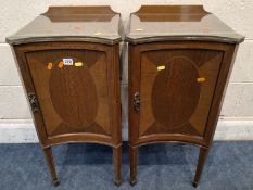 A PAIR OF EDWARDIAN BEDSIDE CUPBOARDS, with a concave front, the single door enclosing a single