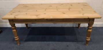 A PINE RECTANGULAR FARMHOUSE STYLE TABLE, with a single drawer to one end, raised on block and