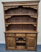 A LARGE MODERN PINE DRESSER, with fruit and vine details, the three-tier plate rack atop a base with