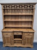 A MODERN PINE DRESSER, the three-tier plate rack atop a breakfront base, fitted with three