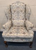 A REPRODUCTION WING BACK ARMCHAIR, with Watts & Co Windsor tapestry Byron upholstery, raised on