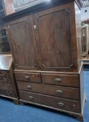 A GEORGIAN MAHOGANY LINEN PRESS, the double cupboard doors enclosing three slides, atop a base