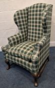AN EARLY 20TH CENTURY WING BACK ARMCHAIR, with later tartan patterned upholstery, a concave front