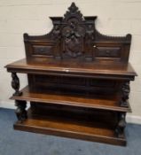 AN EARLY 20TH CENTURY OAK THREE TIER BUFFET, the raised back with various carved details, such as