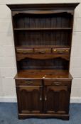 A MODERN STAINED PINE DRESSER, the top with a single shelf and three drawers, atop a base with two