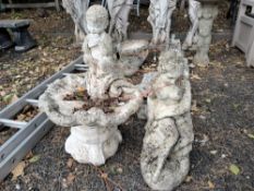 A WEATHERED CONCRETE SHELL SHAPED BIRD BATH, with a small putti playing an instrument, diameter 48cm