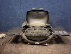 A WEBER PORTABLE GAS BARBECUE with cover and two folding side wings Dimensions:closed width 70cm