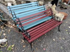 THREE PAINTED CAST ALUMINIUM GARDEN BENCHES, one with a red slatted seat, two with blue slatted