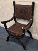 A 20TH CENTURY SAVONAROLLA CHAIR, with an embossed leather back of a figural portrait and floral