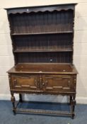 AN EARLY 20TH CENTURY OAK DRESSER, the three tier plate rack atop a base with double cupboard doors,