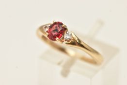 A 9CT GOLD RUBY AND DIAMOND RING, set with a central oval cut ruby, four claw set and flanked with
