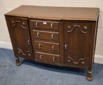 AN EARLY 20TH CENTURY OAK BREAKFRONT SIDEBOARD, fitted with two cupboard doors, flanking four
