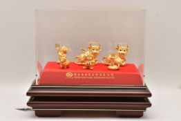 A DISPLAY CASE OF GOLD NOVELTY CHINESE NEW YEAR FIGURES, a wooden display case with a perspex