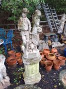 A CONCRETE GARDEN FIGURE ON AN OCTAGONAL STAND in the form of a male and a female figure, 154 cm