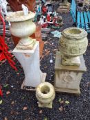 THREE RECONSTITUTED WHITE STONE URNS, possibly marble, one with a concrete stand containing laurel