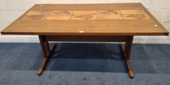 A MID-CENTURY TEAK RECTANGULAR TABLE, with a tile strip down the centre, raised on replacement