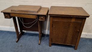 AN EARLY 20TH CENTURY OAK-CASED TREADLE SINGER SEWING MACHINE, along with an oak-cased New Home