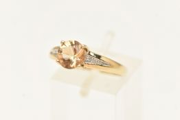 A 9CT YELLOW GOLD GEM SET RING, a circular cut brown beryl 'imperial beryl', flanked with round