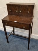 AN EARLY 20TH CENTURY OAK DESK, with two hinged storage sections, flanking double cupboard doors,