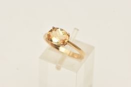 A 9CT YELLOW GOLD GEM SET RING, an oval cut orange stone, assessed as topaz, prong set in yellow
