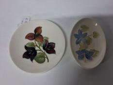 TWO MOORCROFT POTTERY TRINKET DISHES, comprising a Bougainvillaea circular trinket dish, and an oval